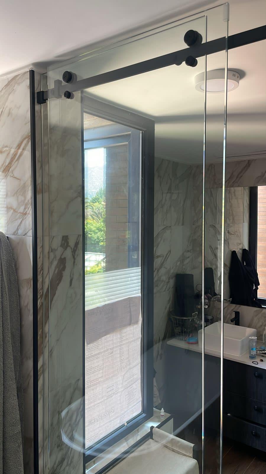 Shower door de vidrio con herraje negro instalado por Raisa