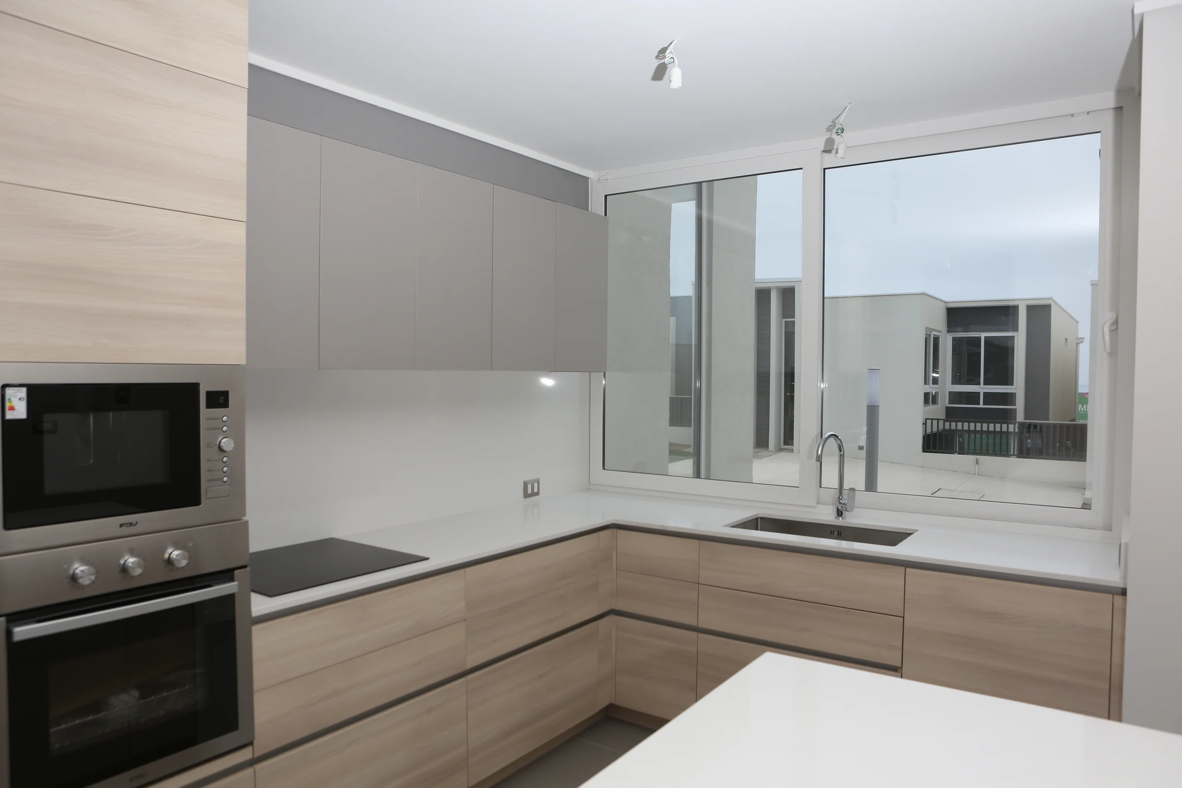 Ventana de PVC blanca instalada en una cocina del proyecto Acrux